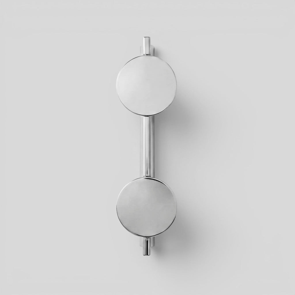 ESTYNE Studio Gallery Studio Sconce in brushed stainless steel with a dual circular light design on a white wall.
