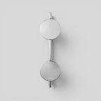 ESTYNE Studio Gallery Studio Sconce in brushed stainless steel with a dual circular light design on a white wall.