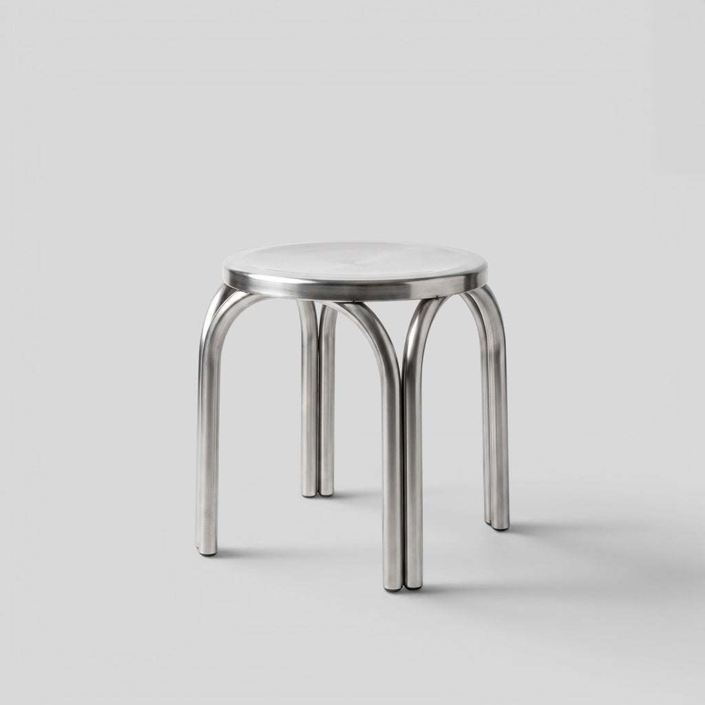 BY–EA Studio Stool in polished stainless steel with a minimalist stackable design, suitable as a seat or side table.