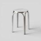 BY–EA Studio Stool in polished stainless steel with a minimalist, stackable industrial design for modern interiors.