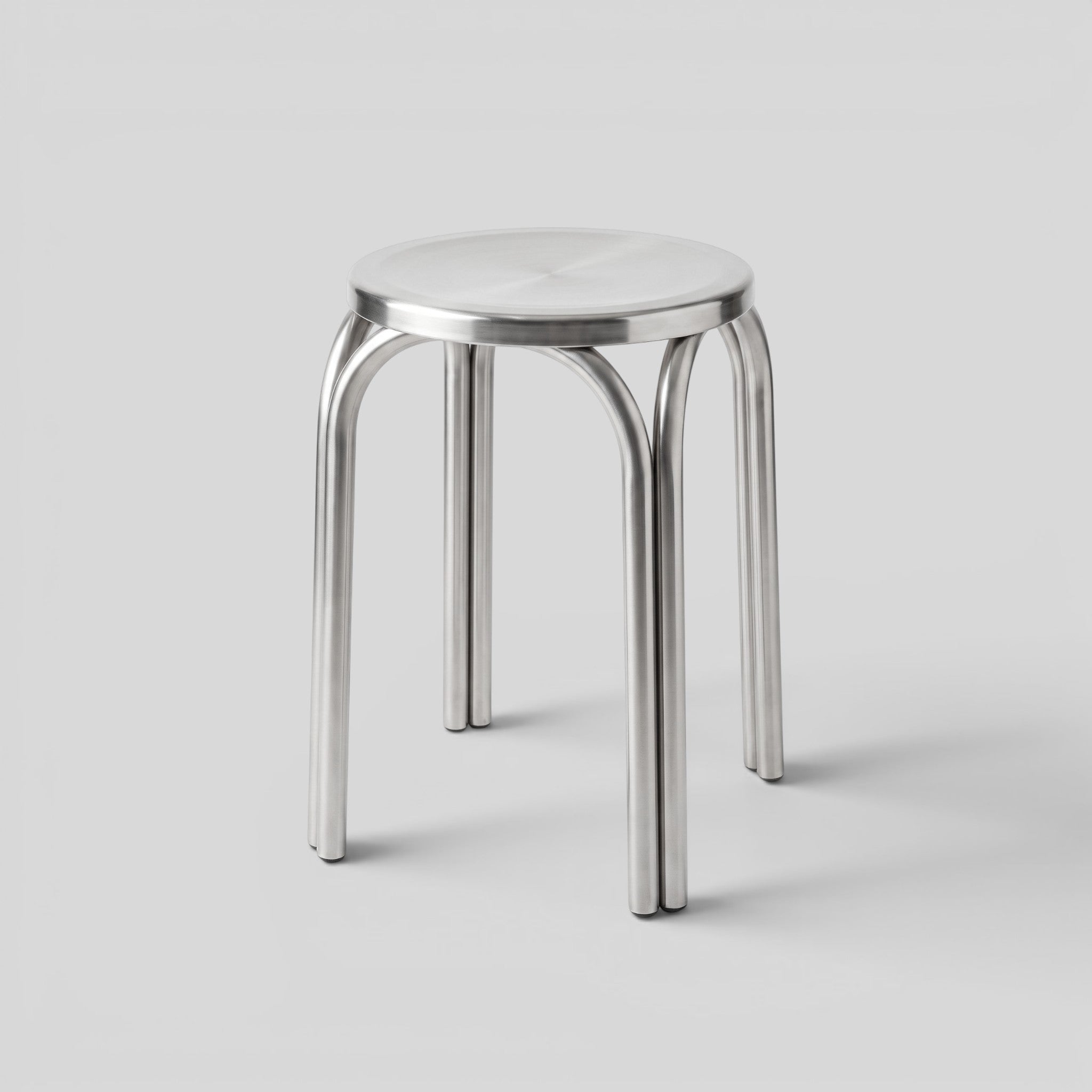 BY–EA Studio Stool in polished stainless steel with a minimalist, stackable industrial design for modern interiors.