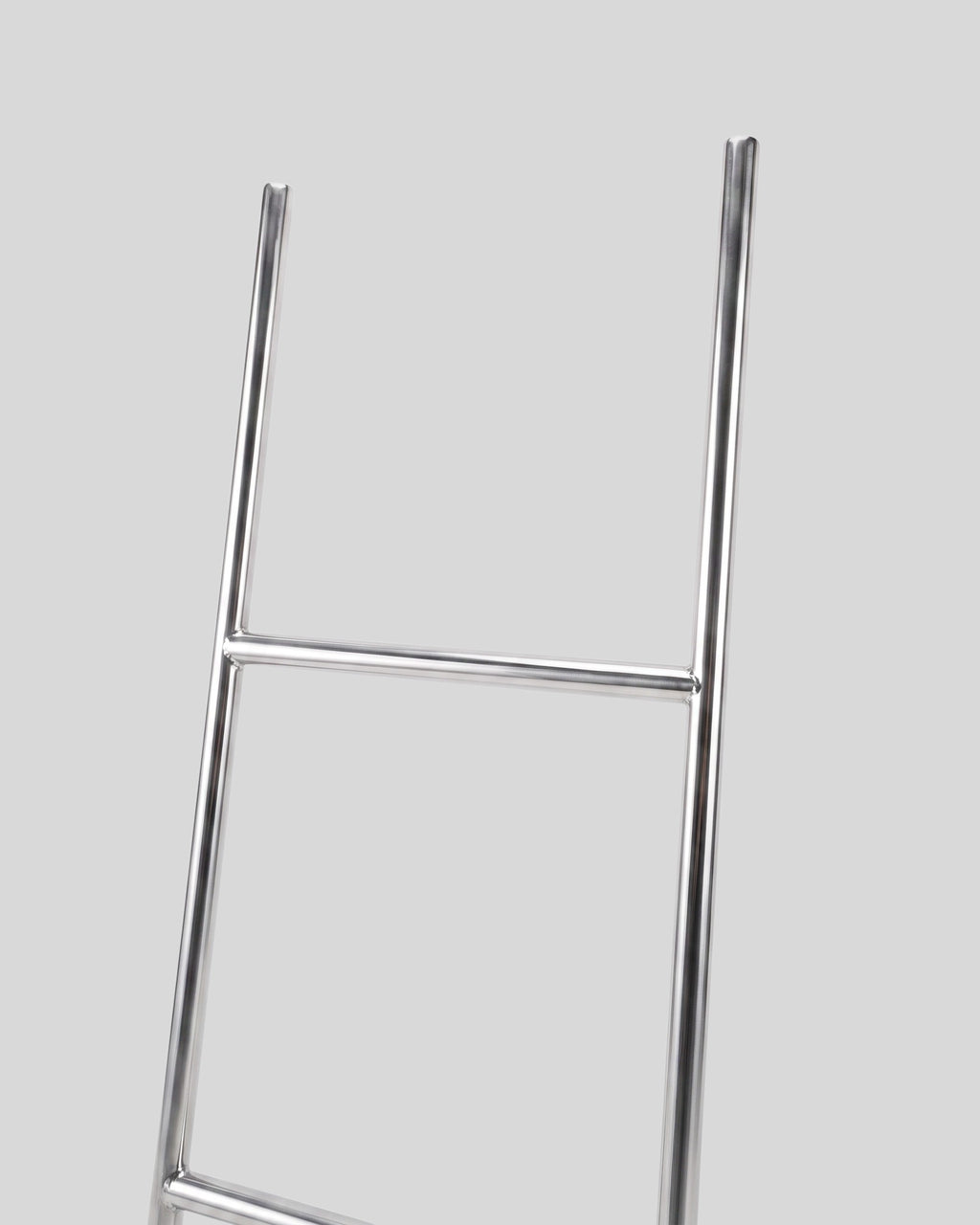 BY–EA Studio Ladder Rack in minimalist stainless steel with a sleek, leaning design for home or creative workspaces.
