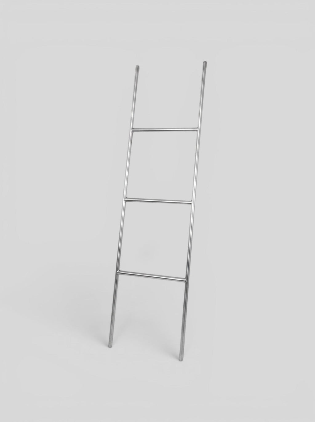 BY–EA The Studio Ladder Rack in brushed stainless steel, a minimalist leaning storage solution for towels or blankets.