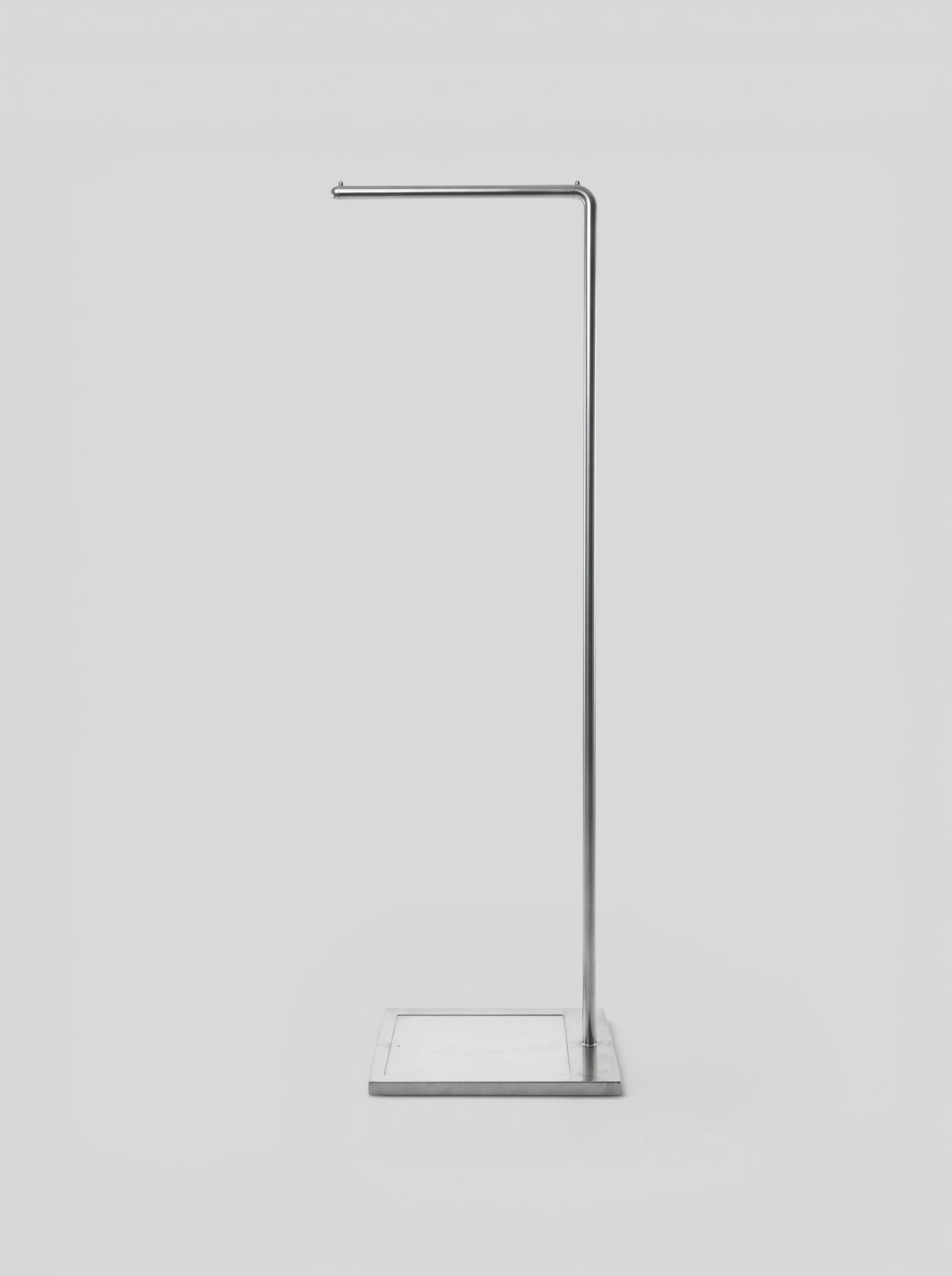 BY–EA Studio Rack featuring a minimalist brushed metal garment stand with a square base and single hanging rail