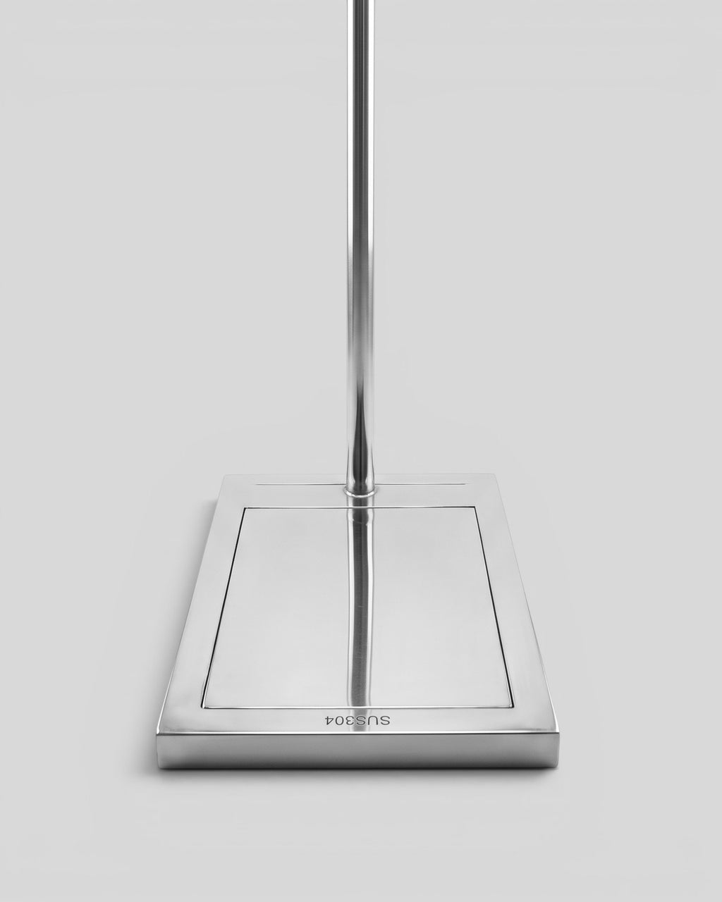 BY–EA Studio Rack featuring a minimalist stainless steel weighted square base for stable clothing and bag display.