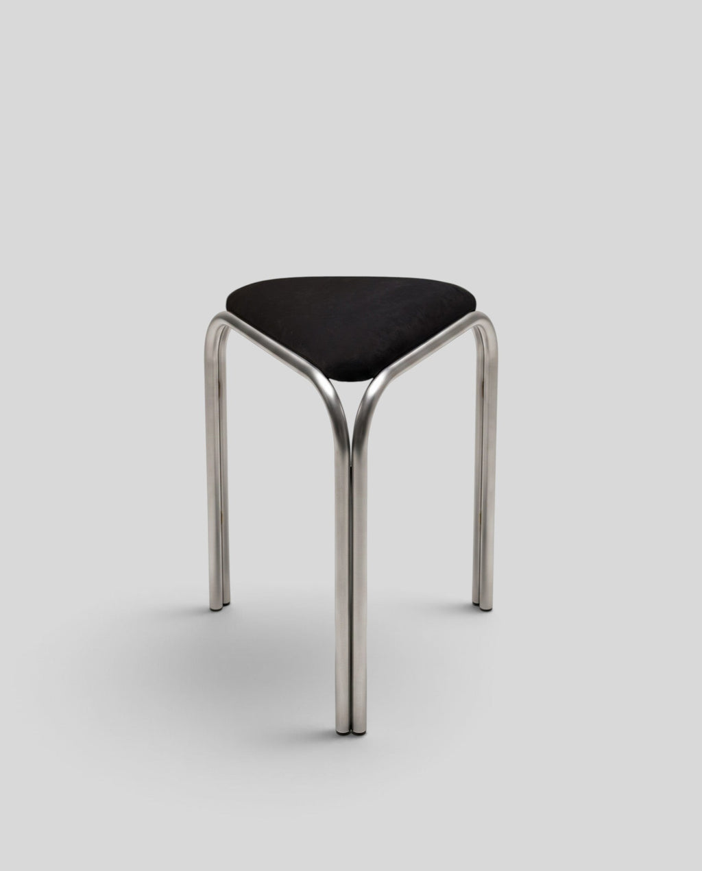 ESTYNE Studio Atelier Stool with a polished stainless steel frame and a soft black velvet triangular seat.
