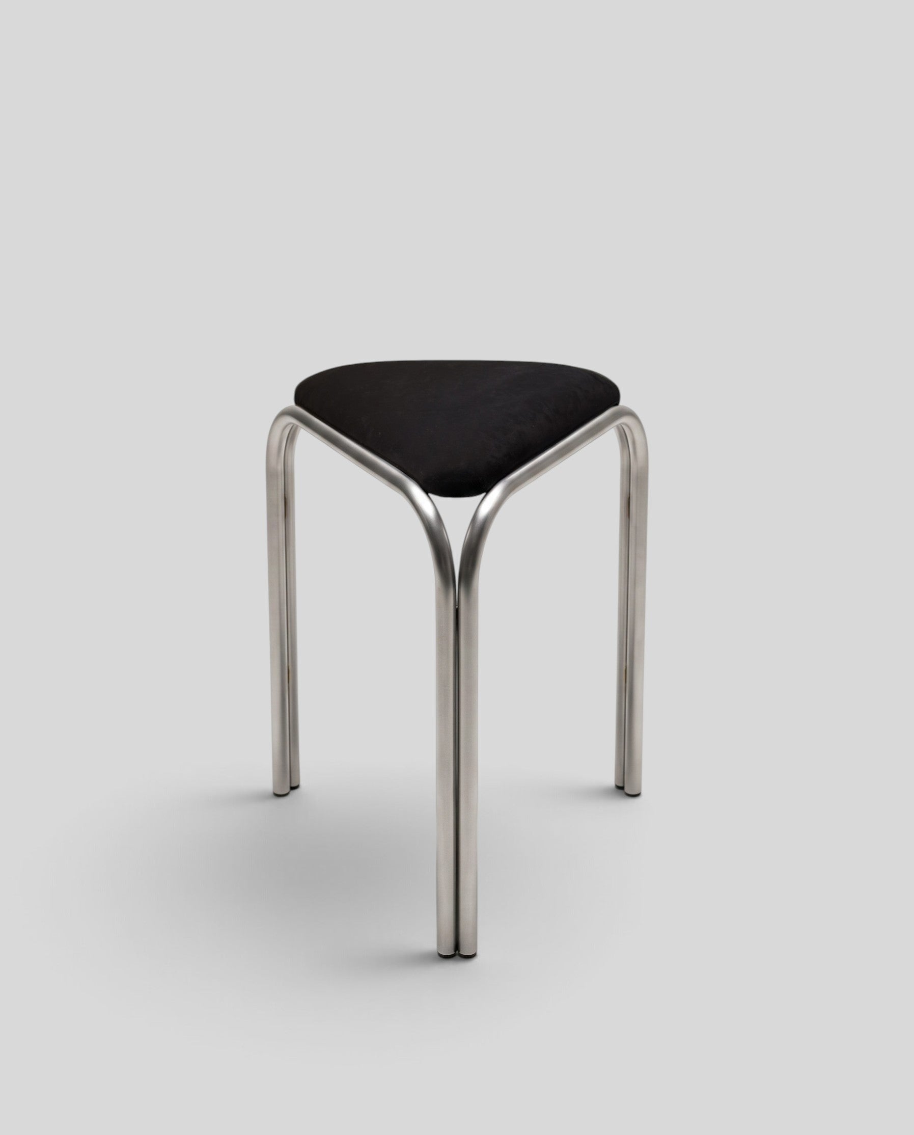 ESTYNE Studio Atelier Stool with a polished stainless steel frame and a soft black velvet triangular seat.