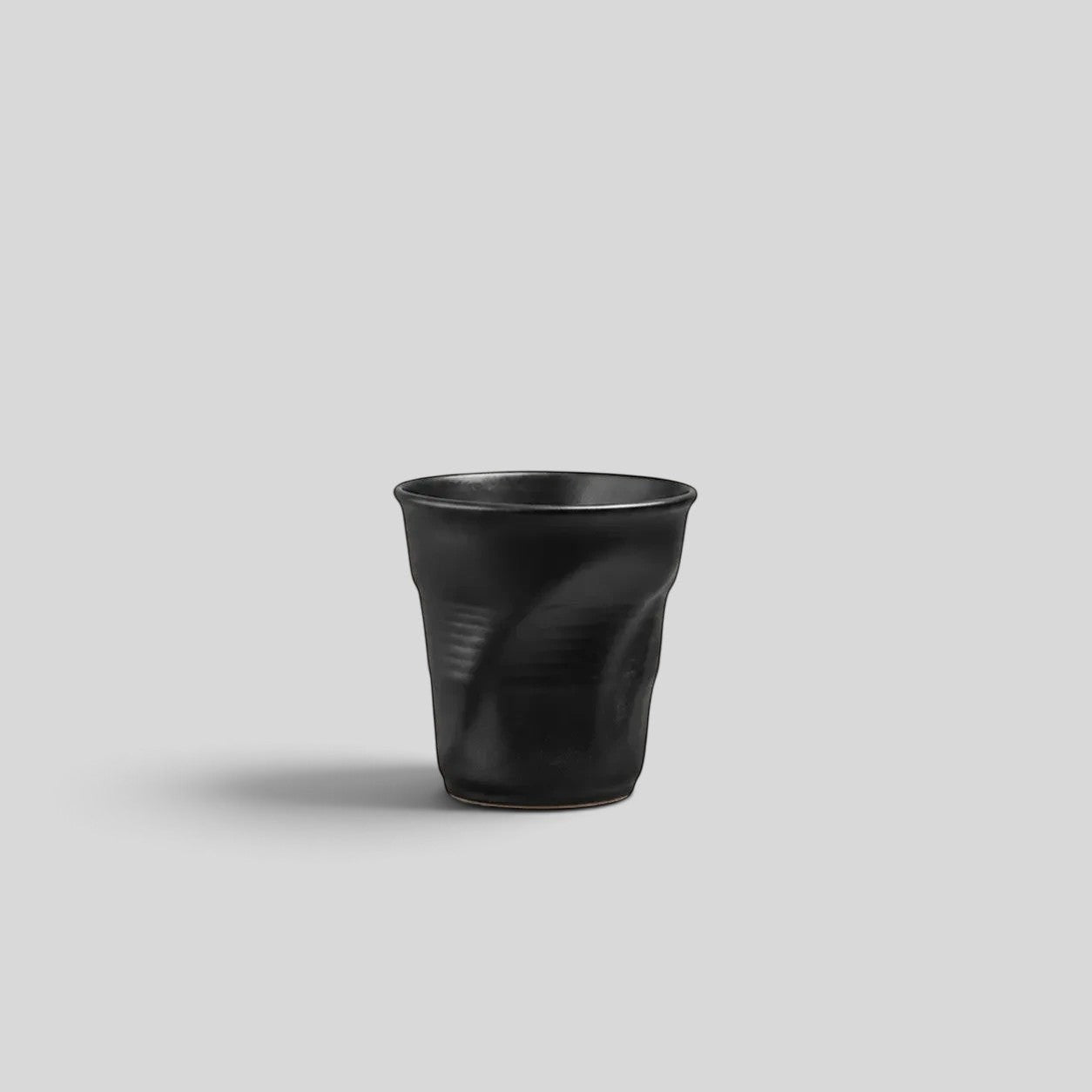 ESTYNE Studio black ceramic Form Cup with a hand-formed sculptural silhouette and a smooth glazed finish.