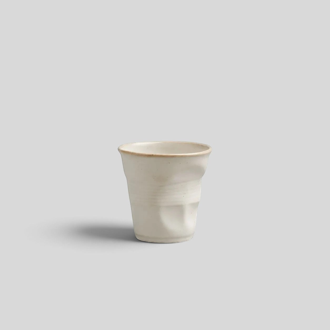 ESTYNE Studio Form Cup in off-white glazed ceramic with a unique hand-formed silhouette for espresso or tea.