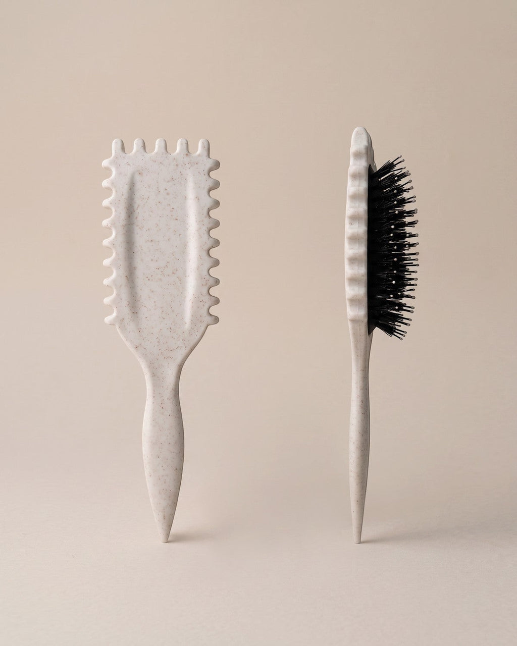 Skin Meets Restore Scalp Brush in speckled beige with flexible black bristles and comfort ridges for gentle detangling.
