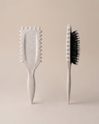 Skin Meets Restore Scalp Brush in speckled beige with flexible black bristles and comfort ridges for gentle detangling.