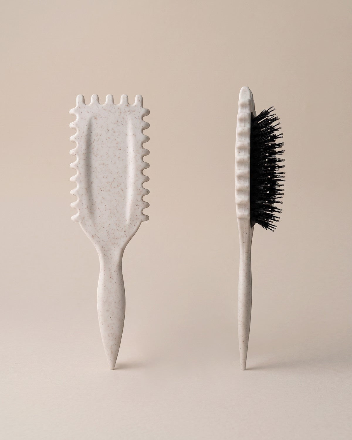 Skin Meets Restore Scalp Brush in speckled beige with flexible black bristles and comfort ridges for gentle detangling.